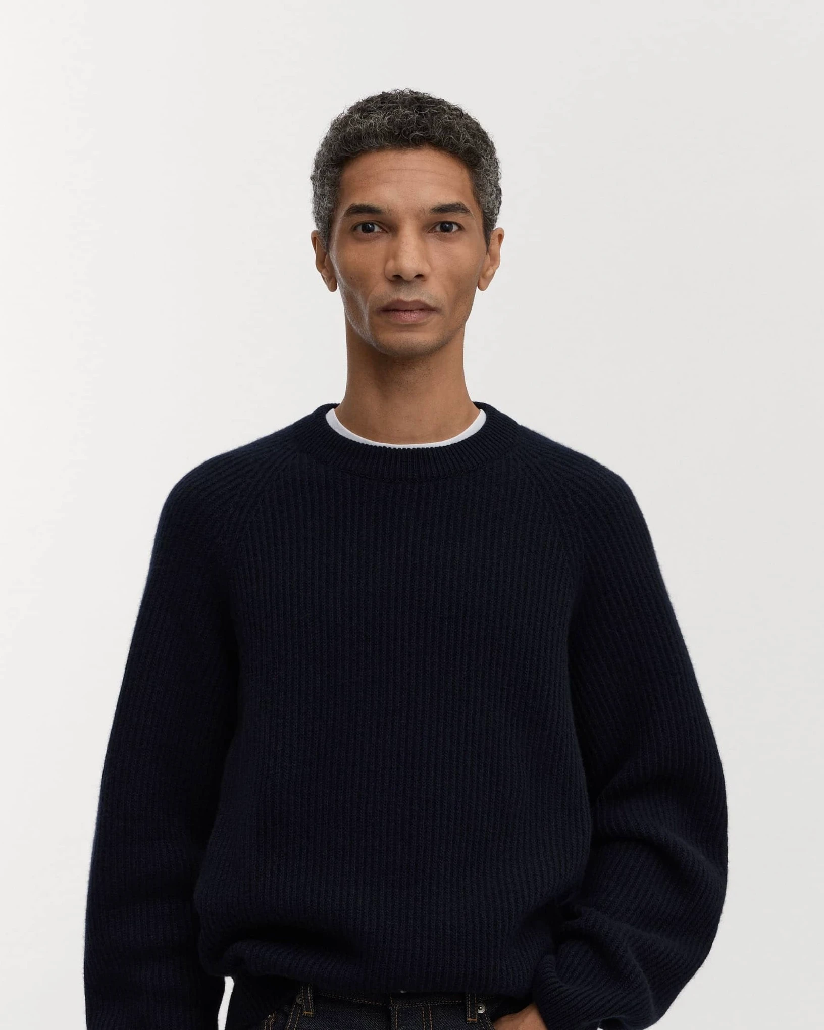 A man wearing the navy Asket Heavy Wool Sweater