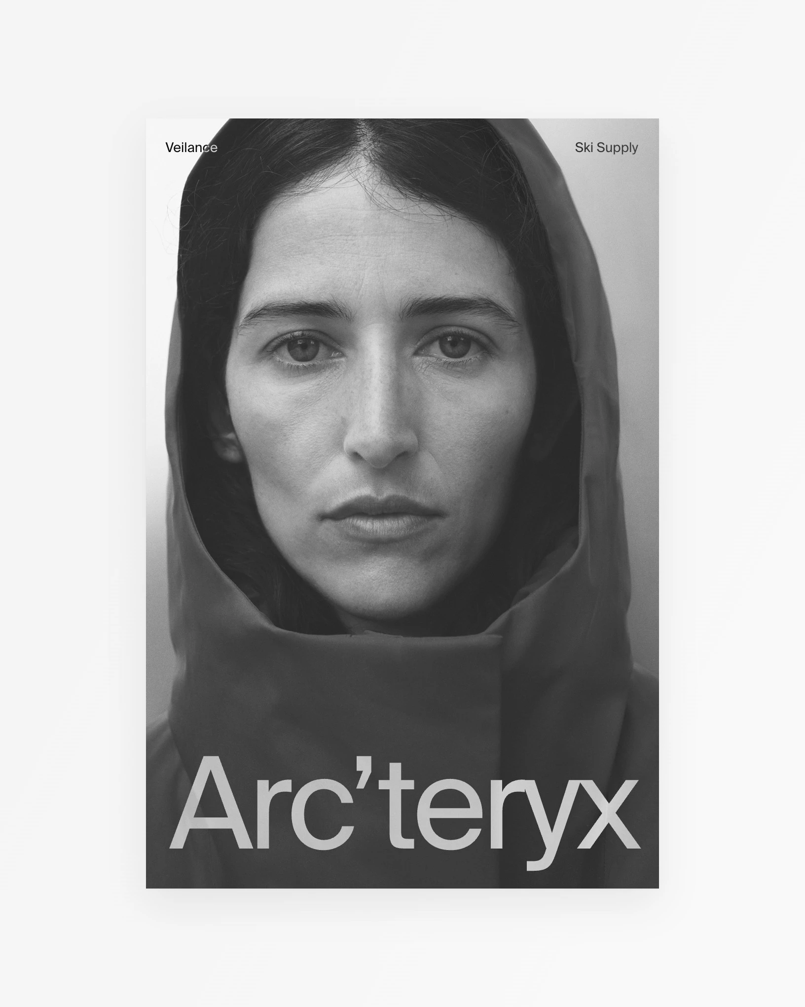Black-and-white Ski Supply pin of an Arc'teryx Veilance hood portrait