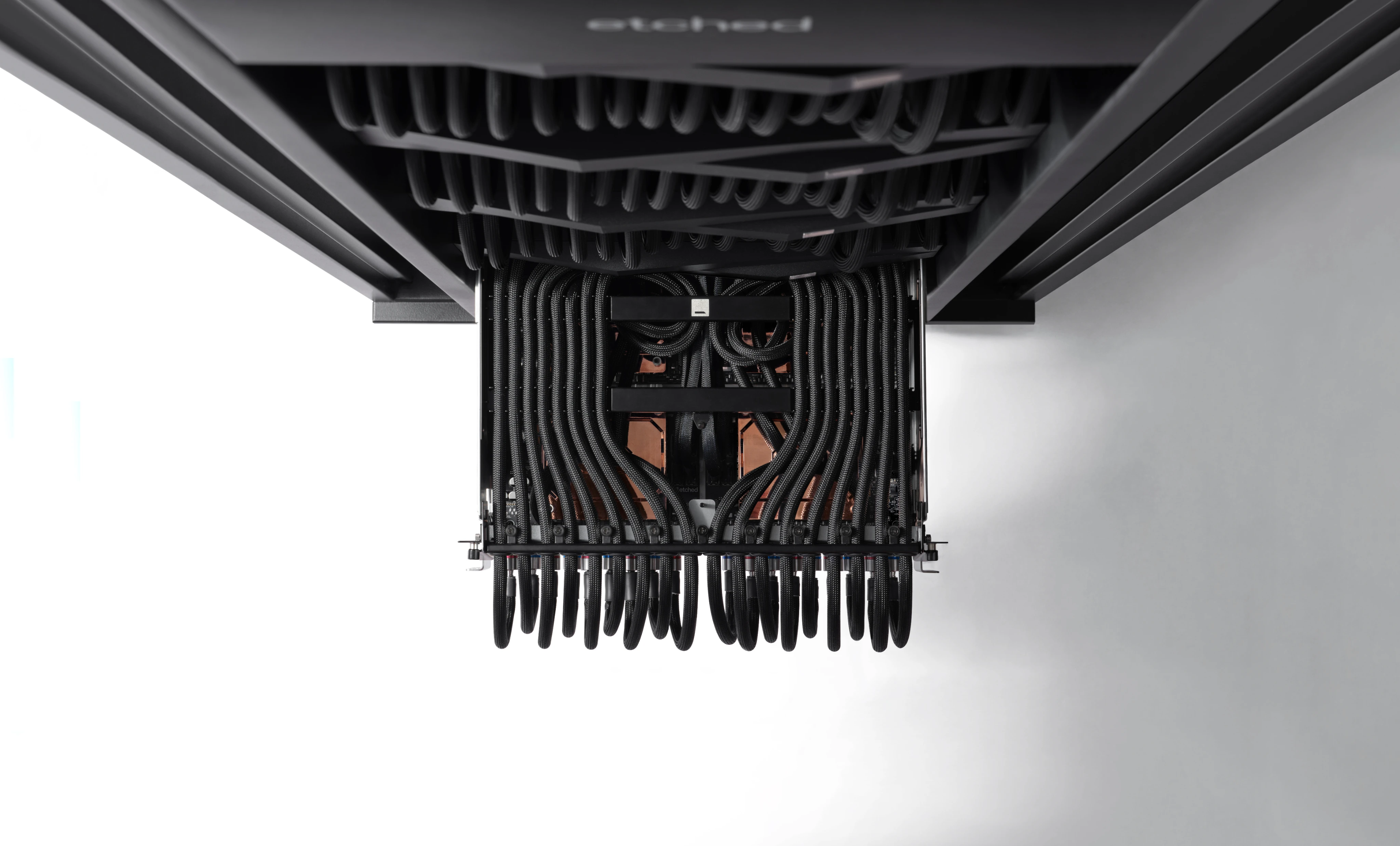 Etched rack hardware viewed from below, framed by braided cabling